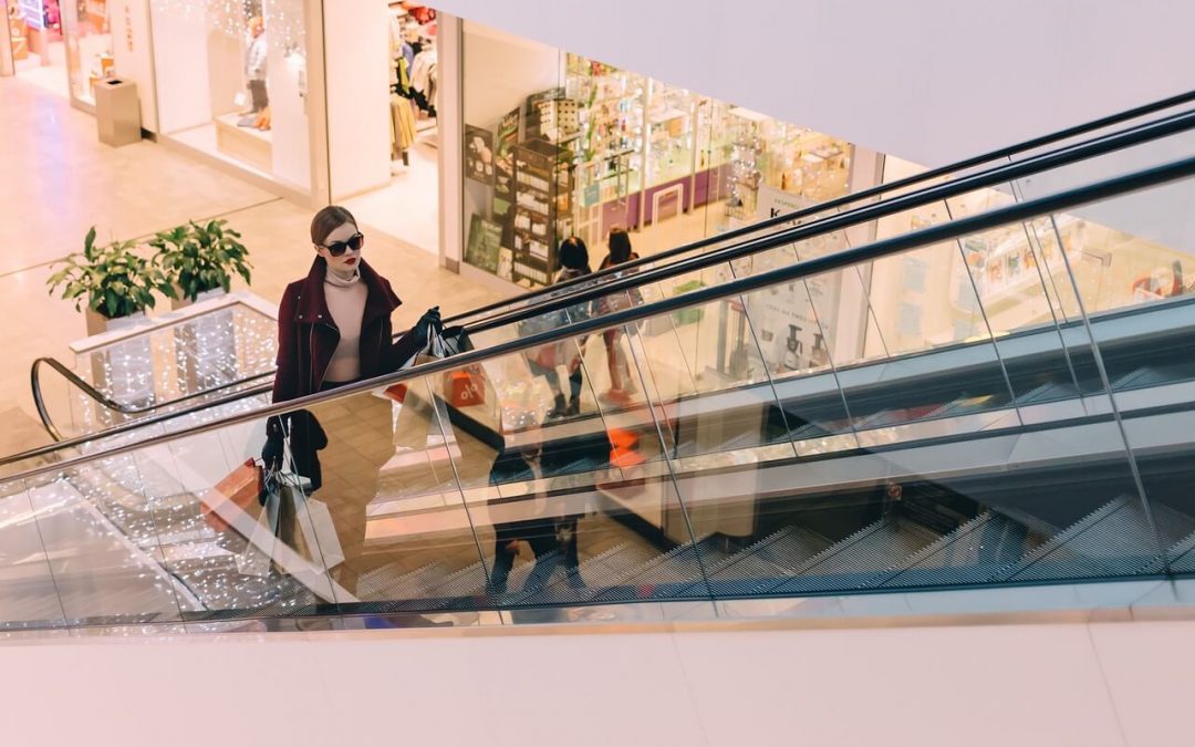 Centros comerciales en Bremen - Imagen ilustrativa mujer de compras subiendo en una escalera mecánica en un centro comercial